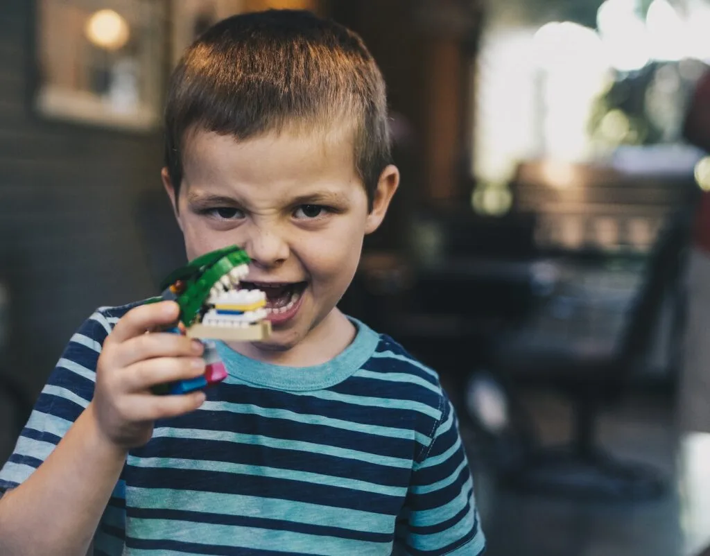 niño jugando con una dentadura de juguete